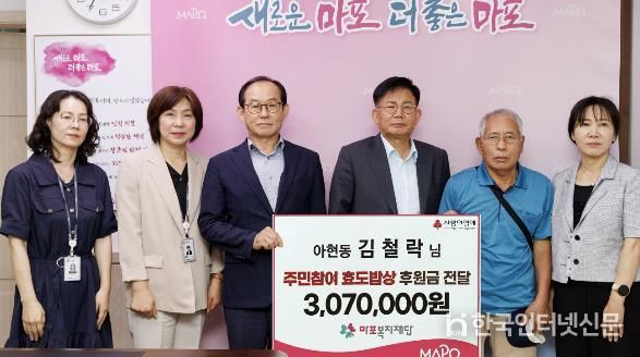 박강수 마포구청장(오른쪽에서 세 번째)이 고이 모은 307만 원을 효도밥상에 기부한 김철락 씨(오른쪽에서 두 번째)와 기념촬영을 하고 있다.