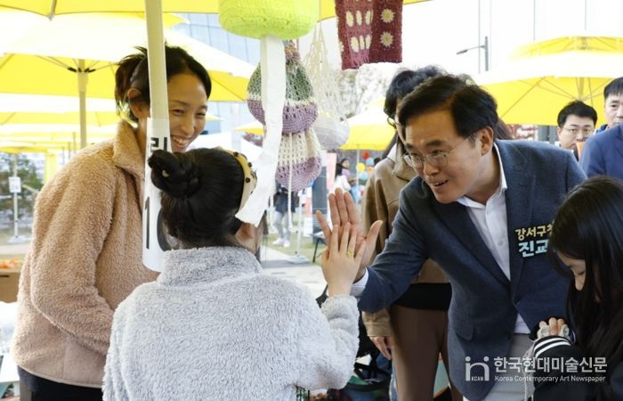진교훈 서울 강서구청장(오른쪽)이 25일 발산근린공원에서 열린 ‘발산마을축제’에서 플리마켓에 참여한 아이와 손을 맞대고 있다.