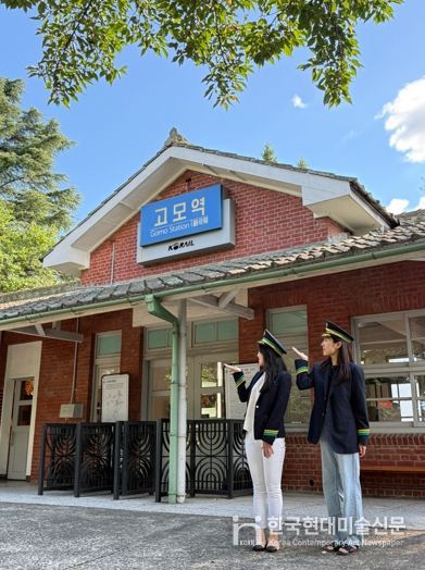관광객들이 고모역에서 역무원 체험을 하고 있다.